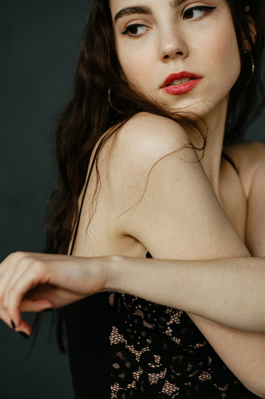 Studio portrait of a young woman with dark wavy hair smiling